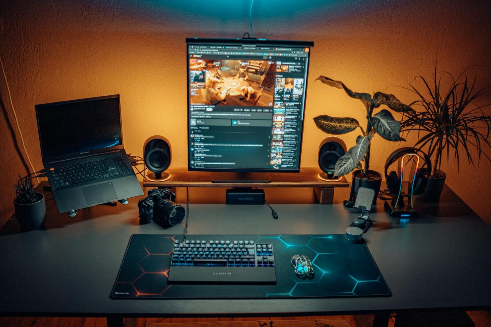A stylish home office desk setup with laptop, screen, camera, and plants creating a modern ambiance.