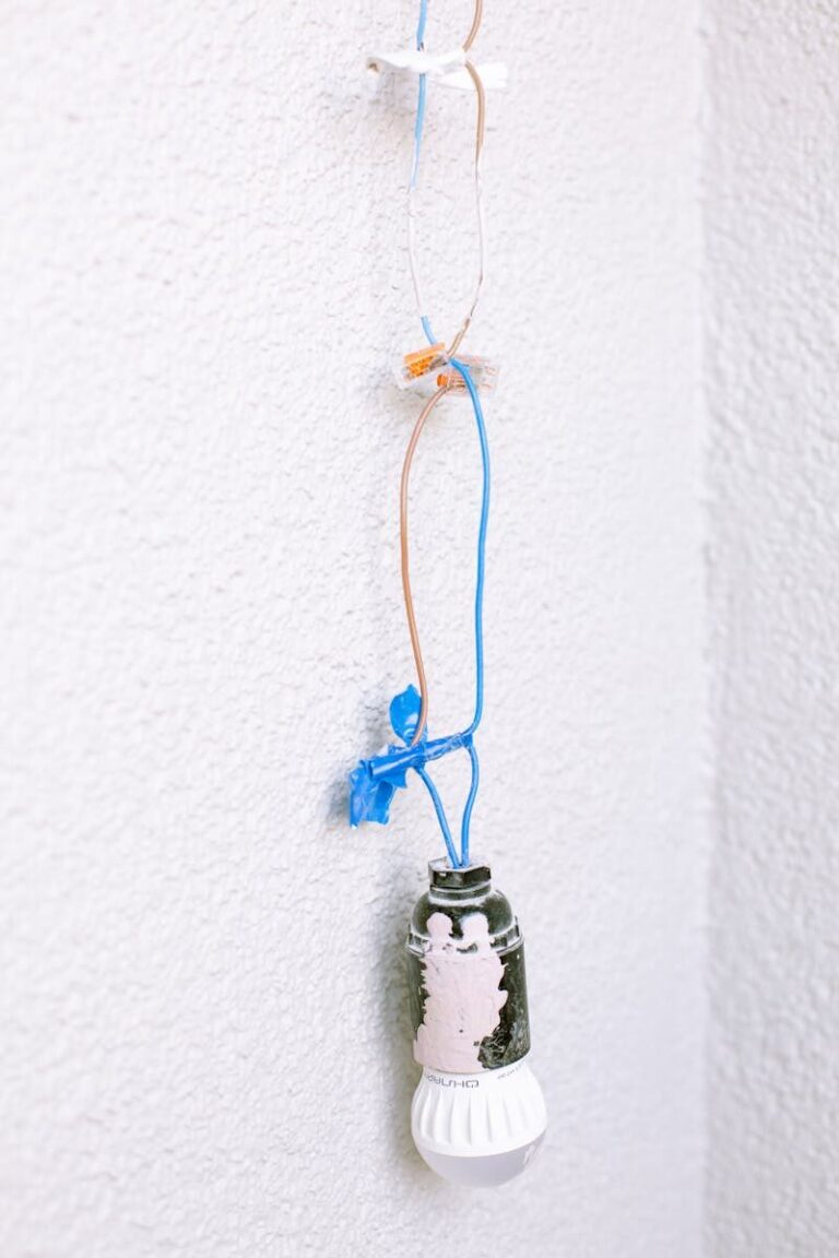 Hanging light bulb with exposed wiring for home renovation or repair.